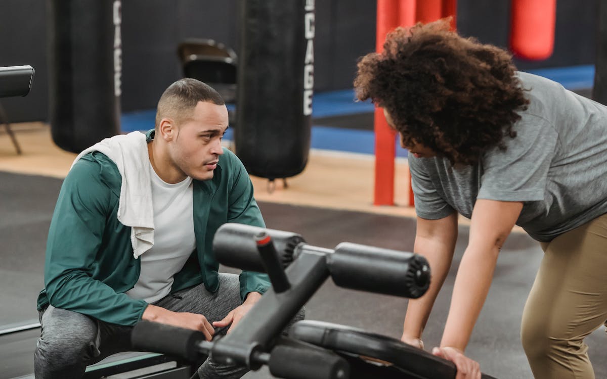 Personal trainer demonstrating an exercise with a client — value-based pricing for coached training in Dubai